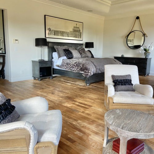 Light hardwood floors ground this luxury bedroom in comfortable warmth